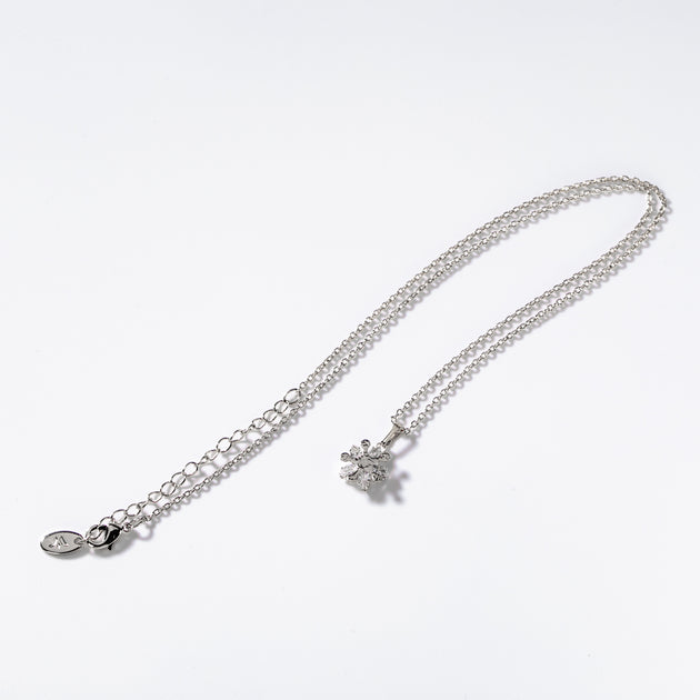 Détail du pendentif Fleurs de Lumière Chogan en métal rhodié avec ses ornements floraux