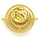 Image du badge Time Turner posé sur un tissu sombre mettant en valeur ses reflets métalliques
