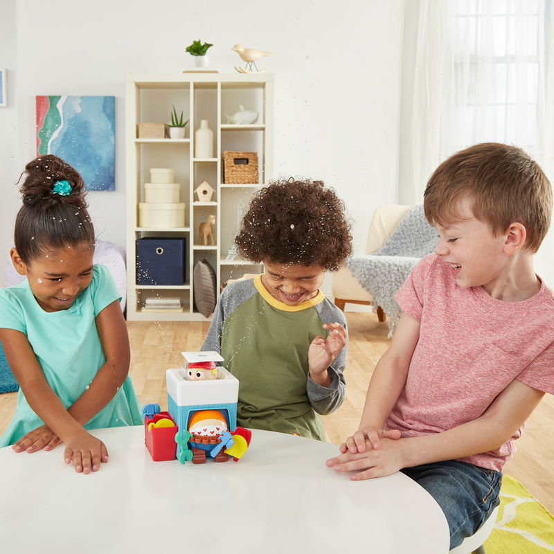 Main d’enfant retirant un outil coloré de la boîte du plombier dans le jeu Hasbro