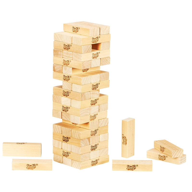 Main d'un enfant retirant délicatement un bloc de la tour Jenga en bois