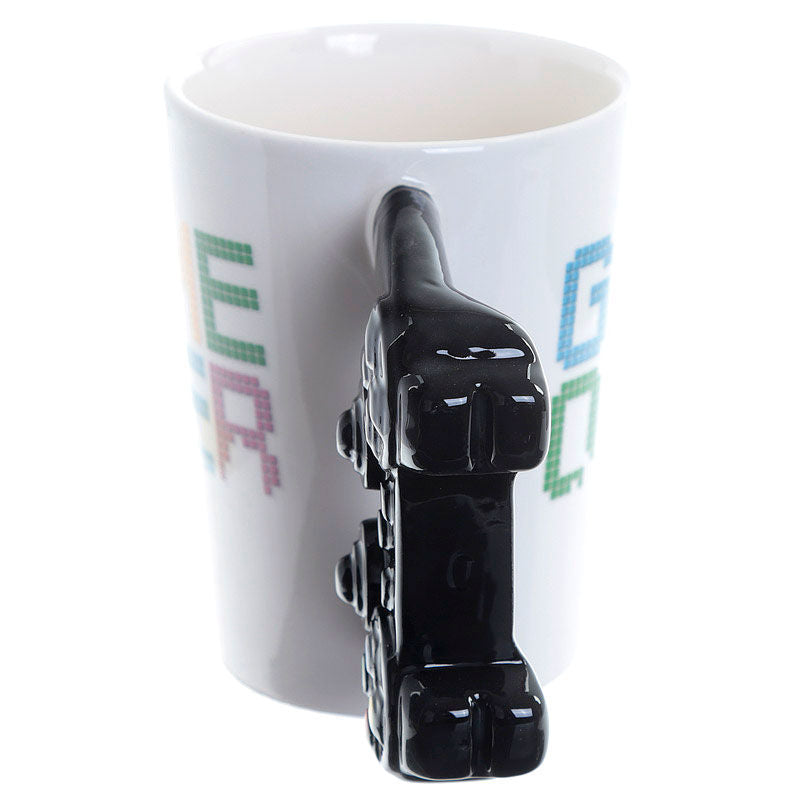 Présentation du mug Game Over PUCKATOR avec une mise en scène café et console de jeux