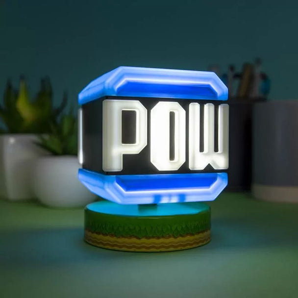 Lampe Super Mario POW de 10 cm allumée sur un bureau moderne avec fond flou