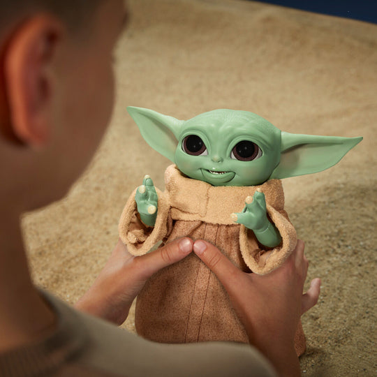 Photo de la figurine animatronique Baby Yoda avec fond thématique Star Wars