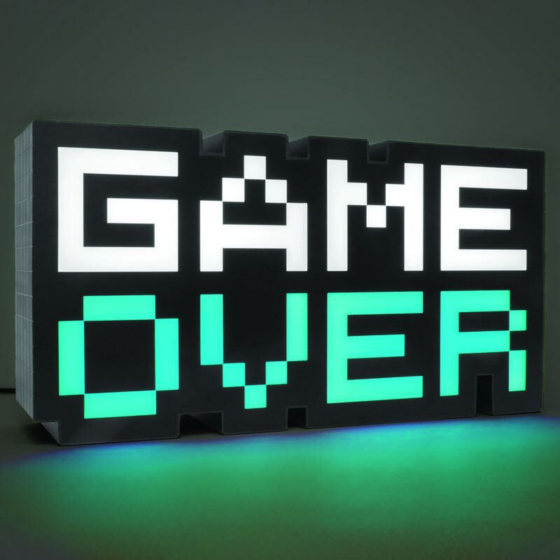 Lampe Game Over 8-BIT posée sur une étagère entourée d’objets de décoration geek