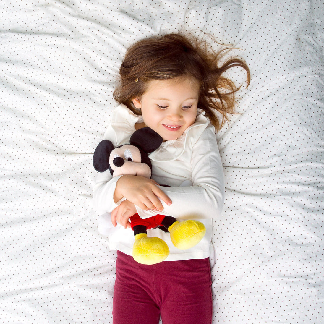 Peluche Mickey Mouse assise sur un fond blanc, mettant en valeur sa taille et ses couleurs