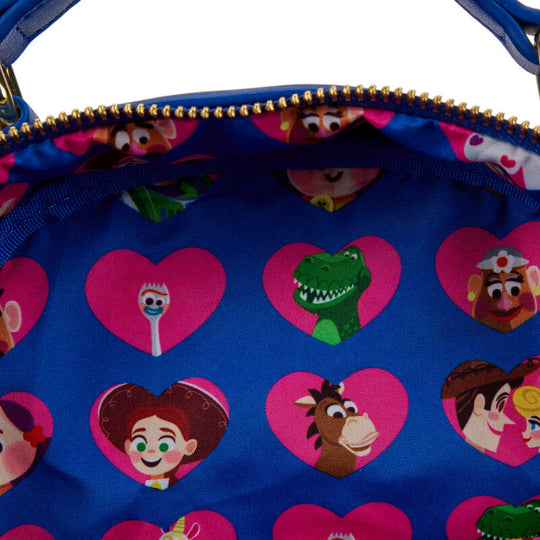 Détail du charm émaillé représentant Woody accroché à la fermeture éclair du sac à dos