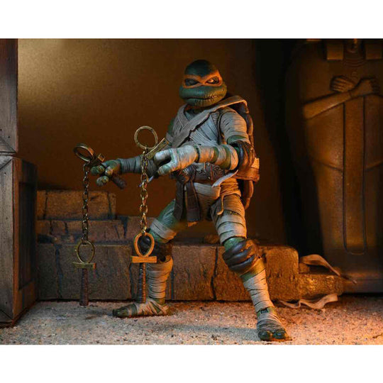 Photo rapprochée des accessoires inclus avec la figurine Michelangelo Tortues Ninja Momie NECA