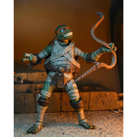Figurine articulée Michelangelo Momie en pose d'action sur fond neutre, 18cm