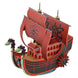 Maquette détaillée du navire pirate Kuja Nine Snake One Piece montée, vue de côté avec ses couleurs vives et ses voiles distinctives.