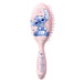 Vue rapprochée des poils doux et du manche ergonomique d'une brosse à cheveux Disney Stitch