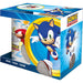 Le mug Sonic The Hedgehog rempli de café chaud posé sur une table avec un arrière-plan lumineux