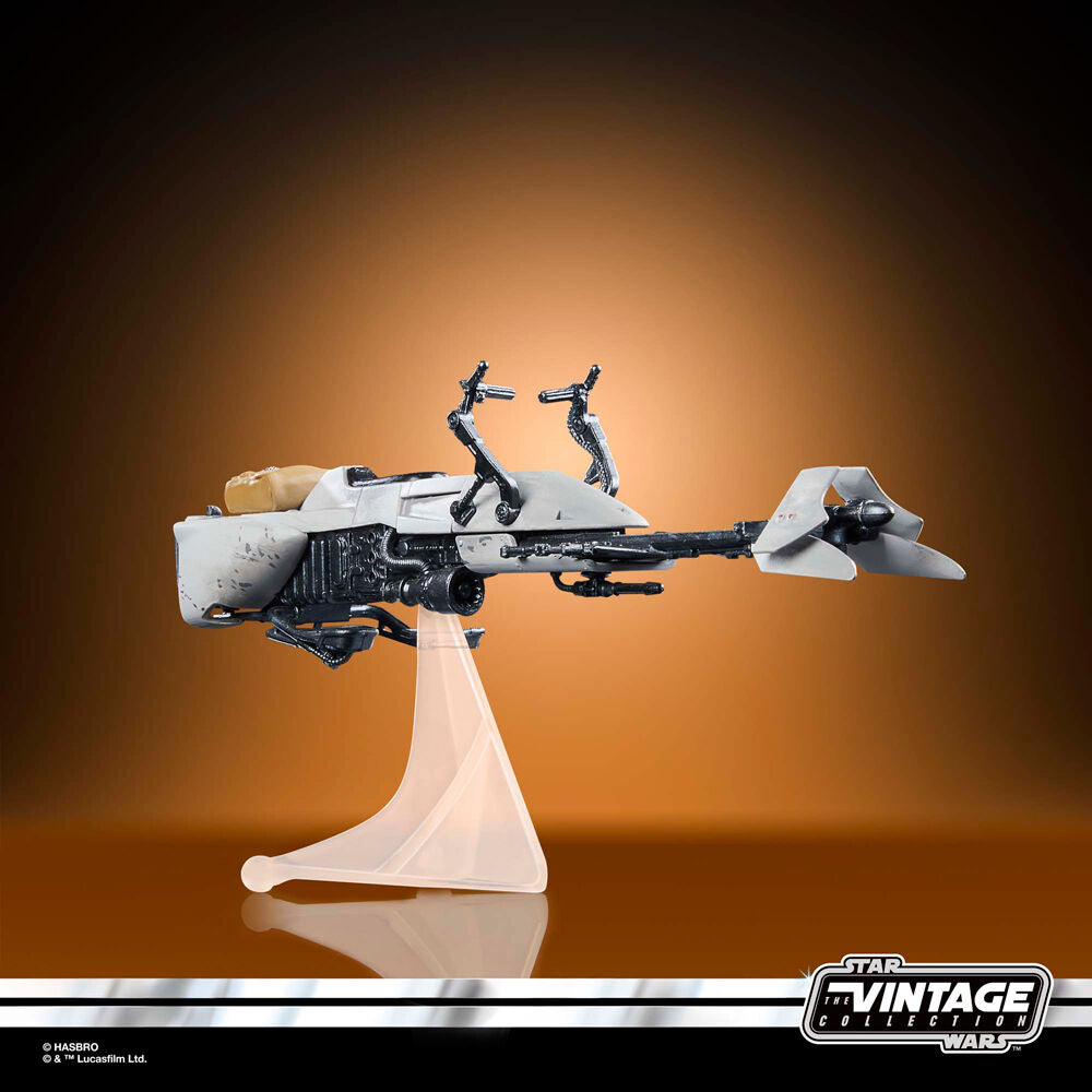 Grogu assis confortablement sur le Speeder Bike à côté du Scout Trooper