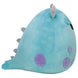 Peluche Sulley Squishmallows Monster Inc posée sur un canapé clair