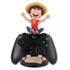 Support Cable Guy Luffy avec manette et accessoires gaming sur bureau organisé