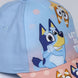 Casquette Bluey assortie portée par un enfant souriant en extérieur
