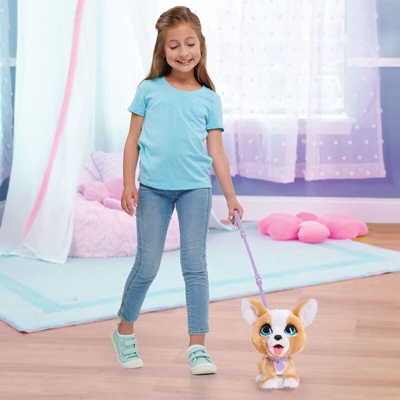Enfant jouant avec la peluche FurReal Poopalots Corgi, montrant l'interaction et les sons émis par la peluche.