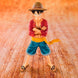 Figurine Monkey D Luffy posée sur un socle avec éclairage mettant en valeur les couleurs vives