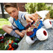 Enfant jouant avec un Hot Wheels Monster Truck sur un terrain accidenté extérieur.