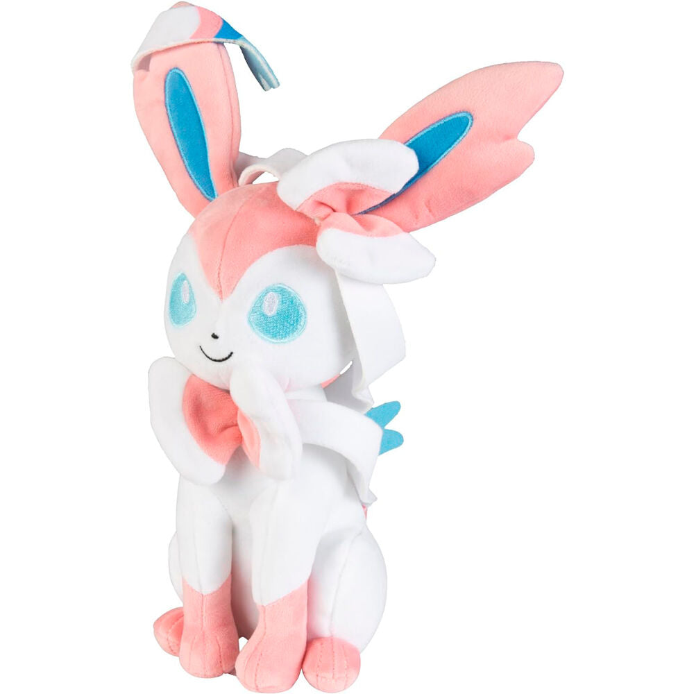 Peluche Sylveon posée sur une surface blanche, mettant en valeur ses 20 cm et son design officiel Pokémon.