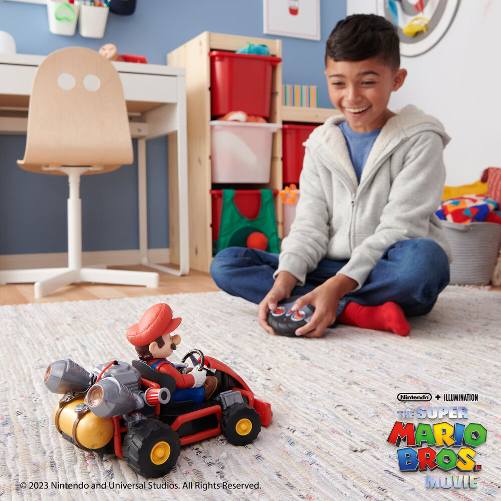 Enfant jouant avec le véhicule télécommandé Super Mario Bros dans un salon lumineux
