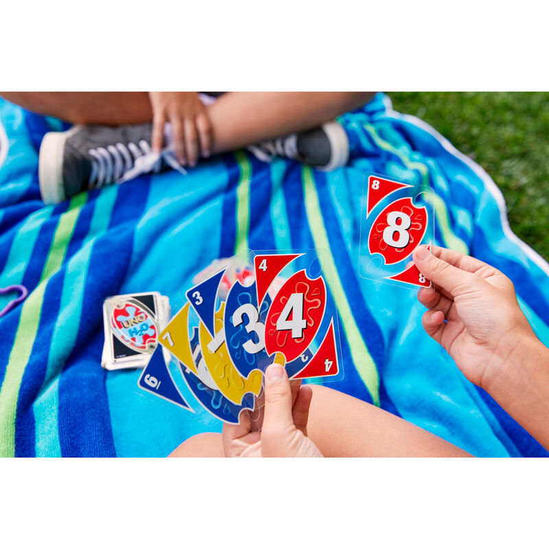 Présentation complète du contenu du jeu UNO H2O To Go avec cartes, clip et instructions visibles.