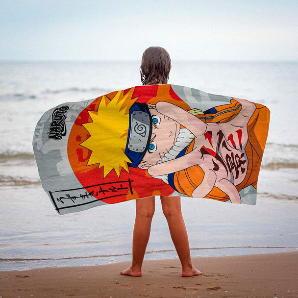 Serviette de plage microfibre Naruto Shippuden CERDÁ posée sur le sable, dimensions 70x140 cm, design coloré et détaillé