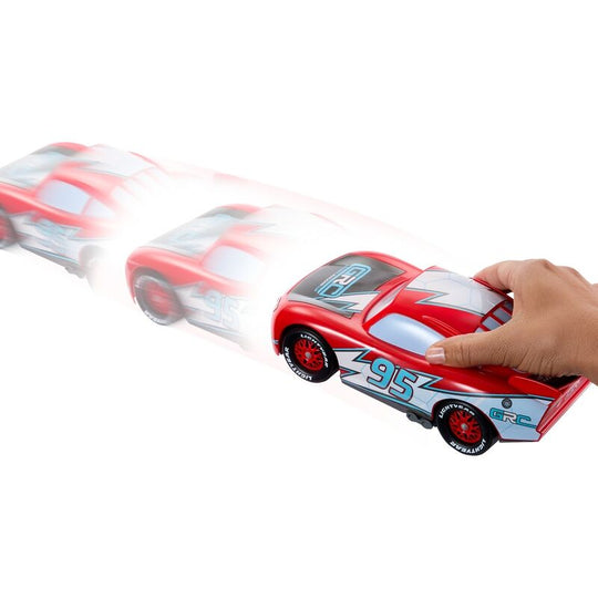 Enfant jouant avec la voiture Lightning McQueen Drift & Race entouré de cônes pour un parcours de course