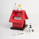 Détail du design coloré et artisanal du calendrier Snoopy Doghouse montrant la niche et Snoopy sculpté