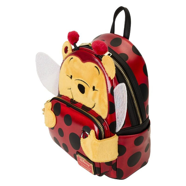 Gros plan sur le pendentif émaillé du zip doré du sac à dos Loungefly Winnie l'Ourson Ladybug