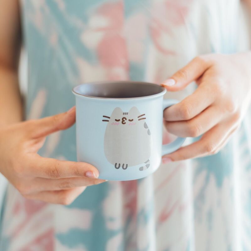 Mug Pusheen posé sur une table en bois avec une boisson chaude à l’intérieur