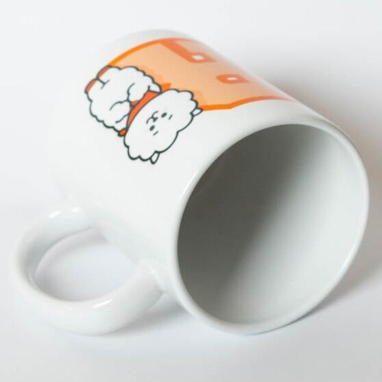 Mug BT21 RJ posé à côté d'une tasse de café, montrant sa taille compacte de 9,5x8 cm