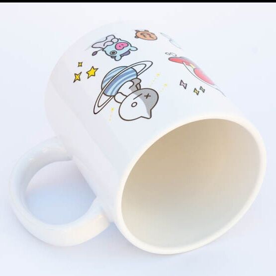 Mug BT21 posé sur une table avec une boisson chaude à l’intérieur