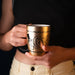 Mug Willy Wonka Golden Ticket posé sur une table en bois avec une boisson chaude