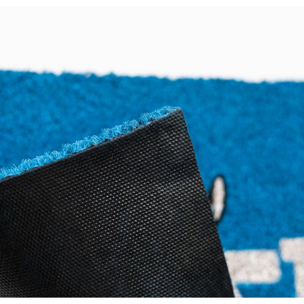 Paillasson Stitch Ohana posé devant une porte d'entrée avec fibre de coco visible et base antidérapante