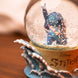 Boule à neige Disney Stitch posée sur une étagère décorative avec fond flou