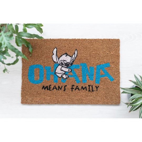 Paillasson Stitch Ohana posé devant une porte d'entrée, décoré avec un motif coloré Stitch