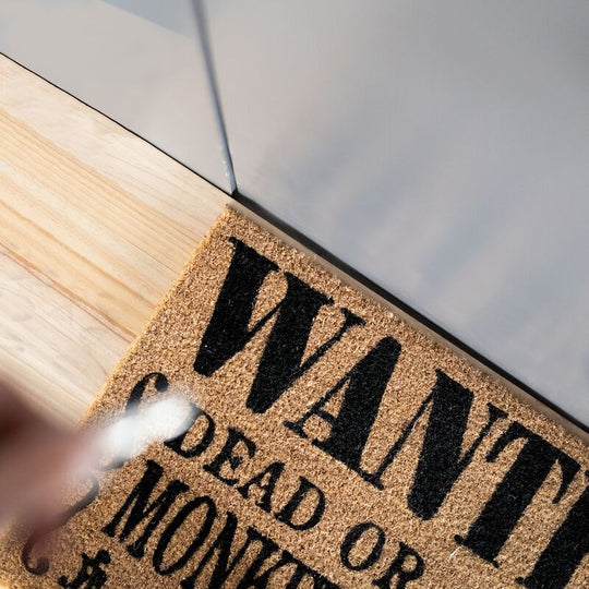 Paillasson One Piece Monkey D Luffy placé devant une porte d'entrée moderne