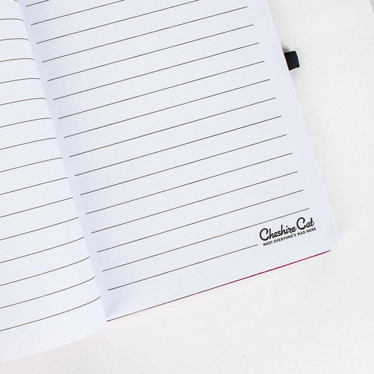 Cahier Cheshire posé sur un bureau avec accessoires d’écriture colorés