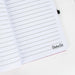 Cahier Cheshire posé sur un bureau avec accessoires d’écriture colorés