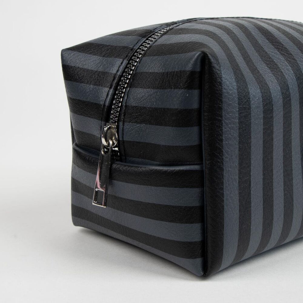 Trousse Wednesday CERDÁ posée sur une surface avec accessoires de beauté à côté