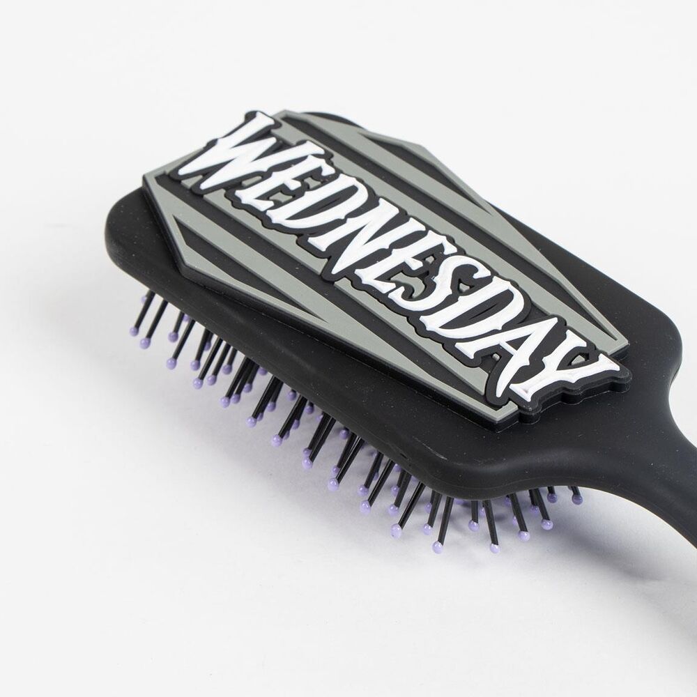 Brosse Wednesday CERDÁ posée sur une surface claire, mettant en avant sa forme compacte