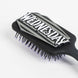 Brosse Wednesday CERDÁ posée sur une surface claire, mettant en avant sa forme compacte