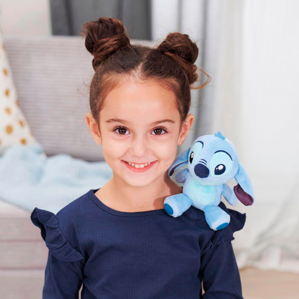 Peluche Stitch posée sur une épaule, illustrant son maintien sécurisé grâce à l'aimant