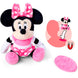 Peluche Minnie Disney posée sur une épaule, illustrant son utilisation pratique grâce à l'aimant