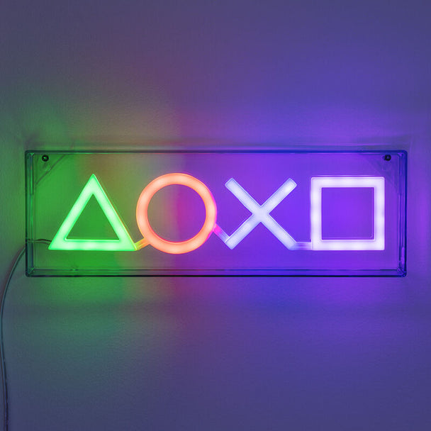 Lampe LED PlayStation Symbols PALADONE allumée posée sur une table, éclairage doux et ambiance gaming
