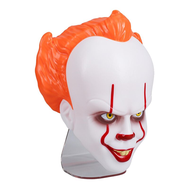 Lampe IT Pennywise 24cm posée sur une table avec ambiance d'horreur