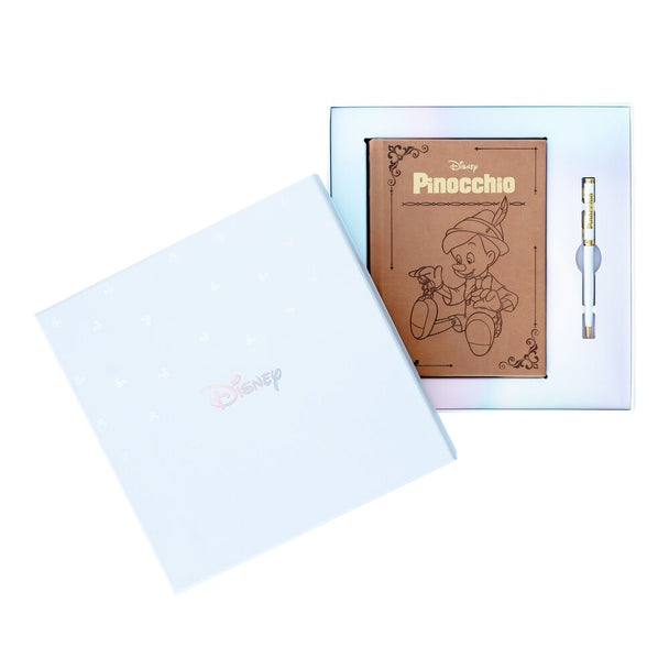 Stylo assorti au cahier Pinocchio présenté à côté du carnet dans le coffret cadeau