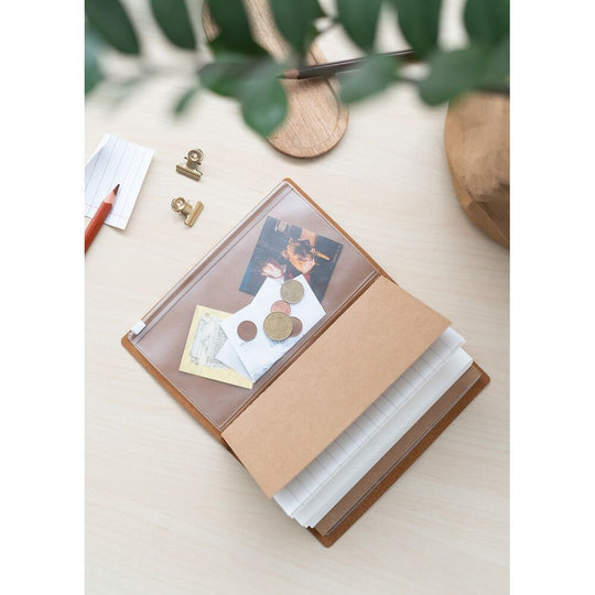 Carnet Harry Potter Hufflepuff posé sur une table avec accessoires de voyage
