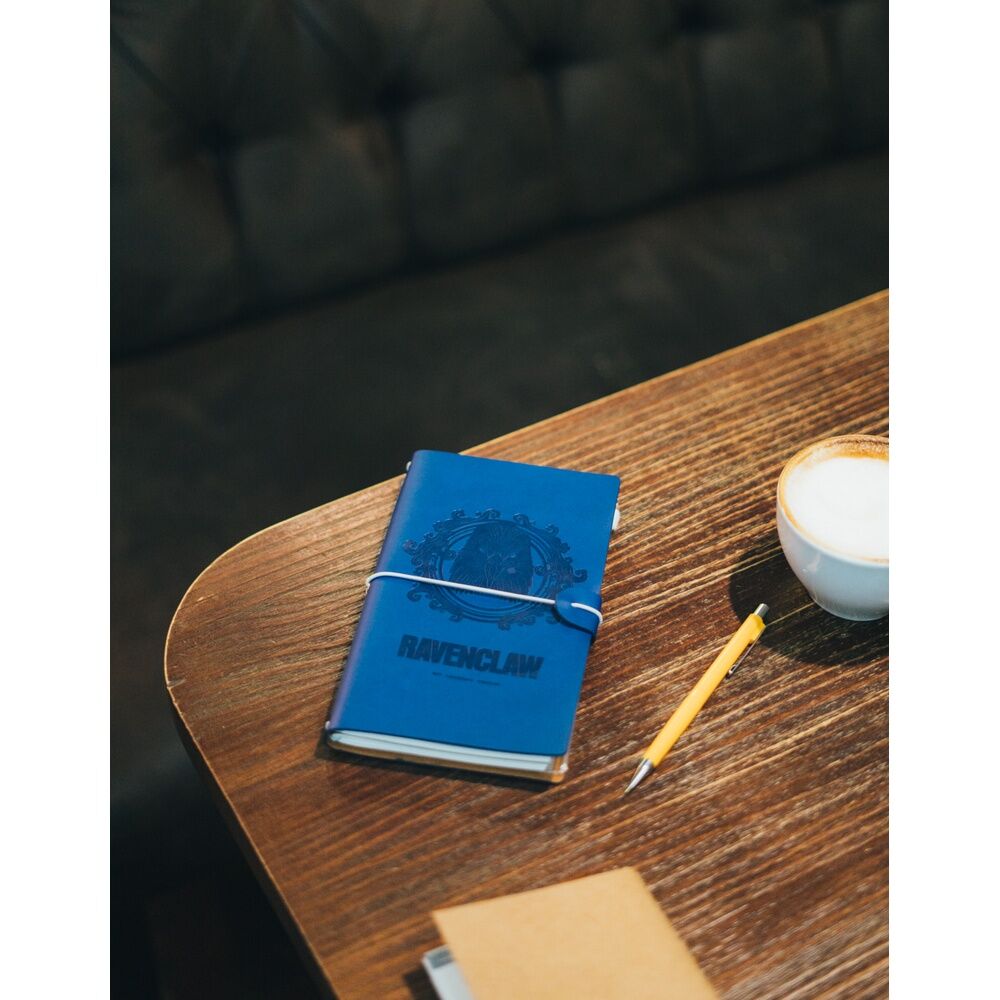 Photo du carnet posé sur une table avec une plume et encre, ambiance Harry Potter