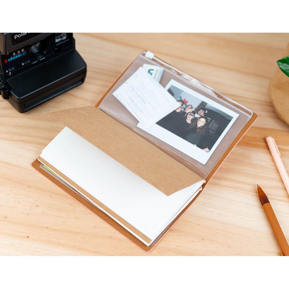 Vue d’ensemble du carnet Pusheen posé sur une table avec accessoires de voyage autour
